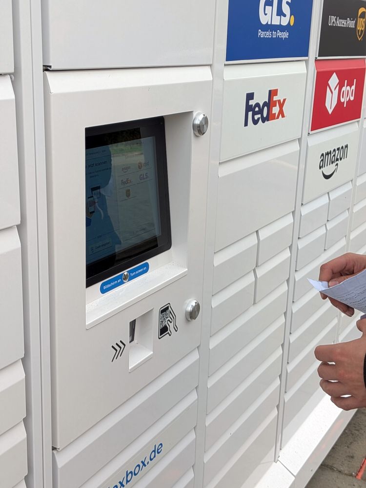 Kunde scannt den QR-Code am Bildschirm der 24/7-Box